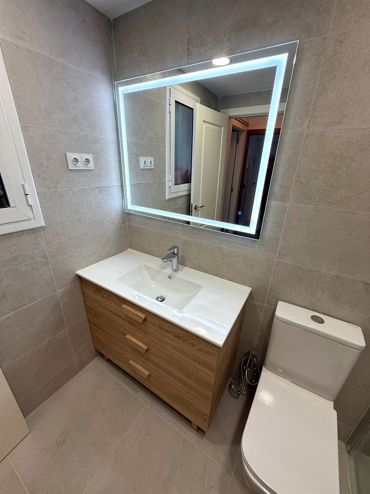 Mueble de baño con lavabo y espejo retroiluminado