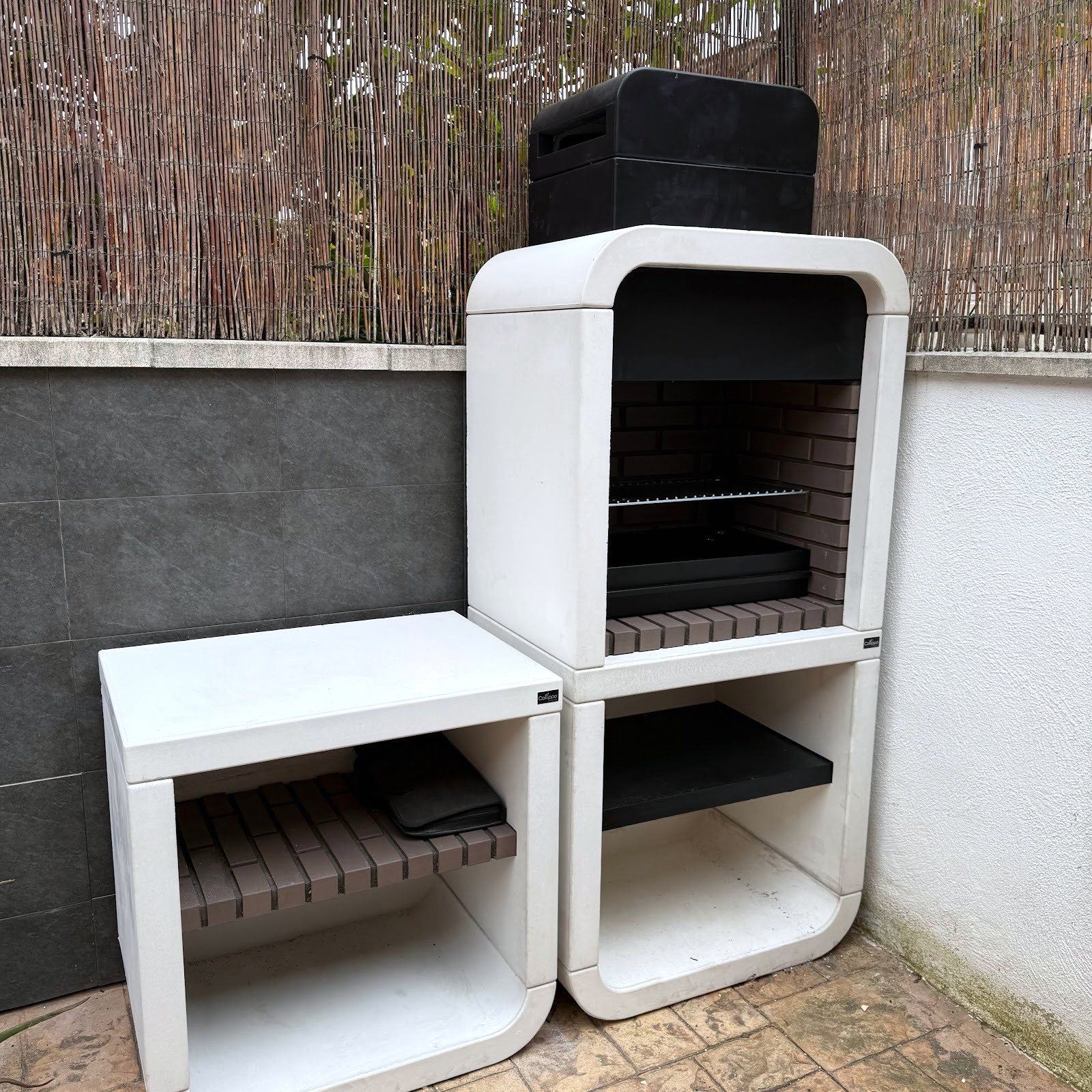 Barbacoa de obra terminada en un patio de Tarragona, con su encimera al lado