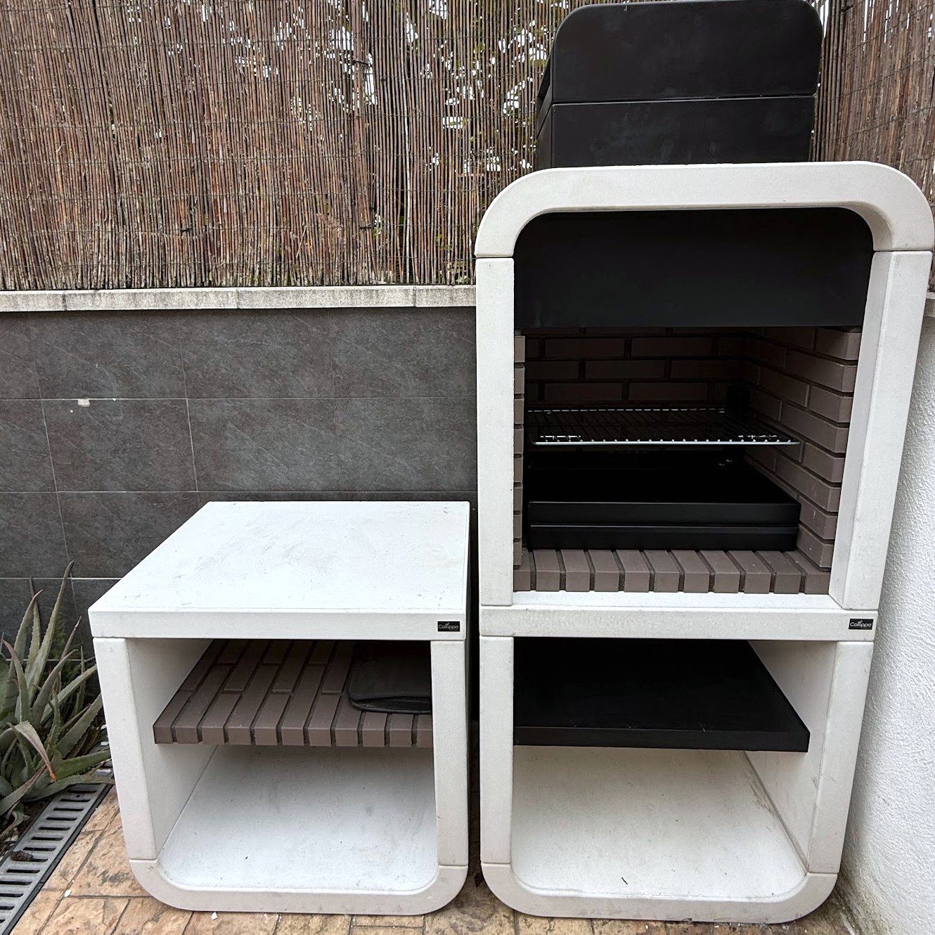 Detalle de la barbacoa de obra con el hogar de ladrillo y la parrilla