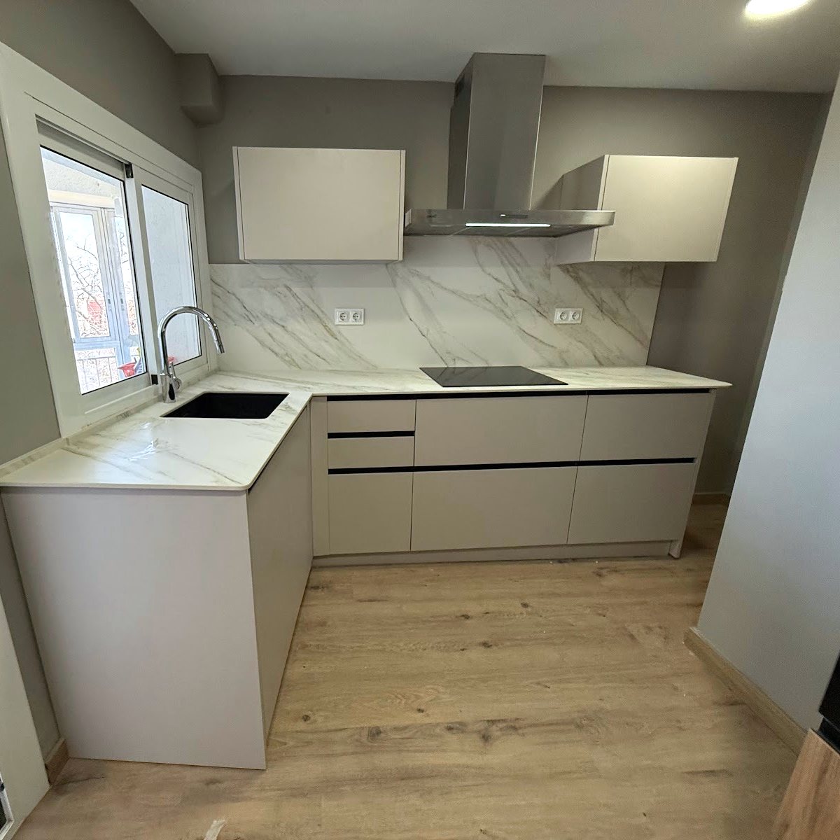 Cocina reformada entera en Tarragona, con península, frente de mármol y campana de acero
