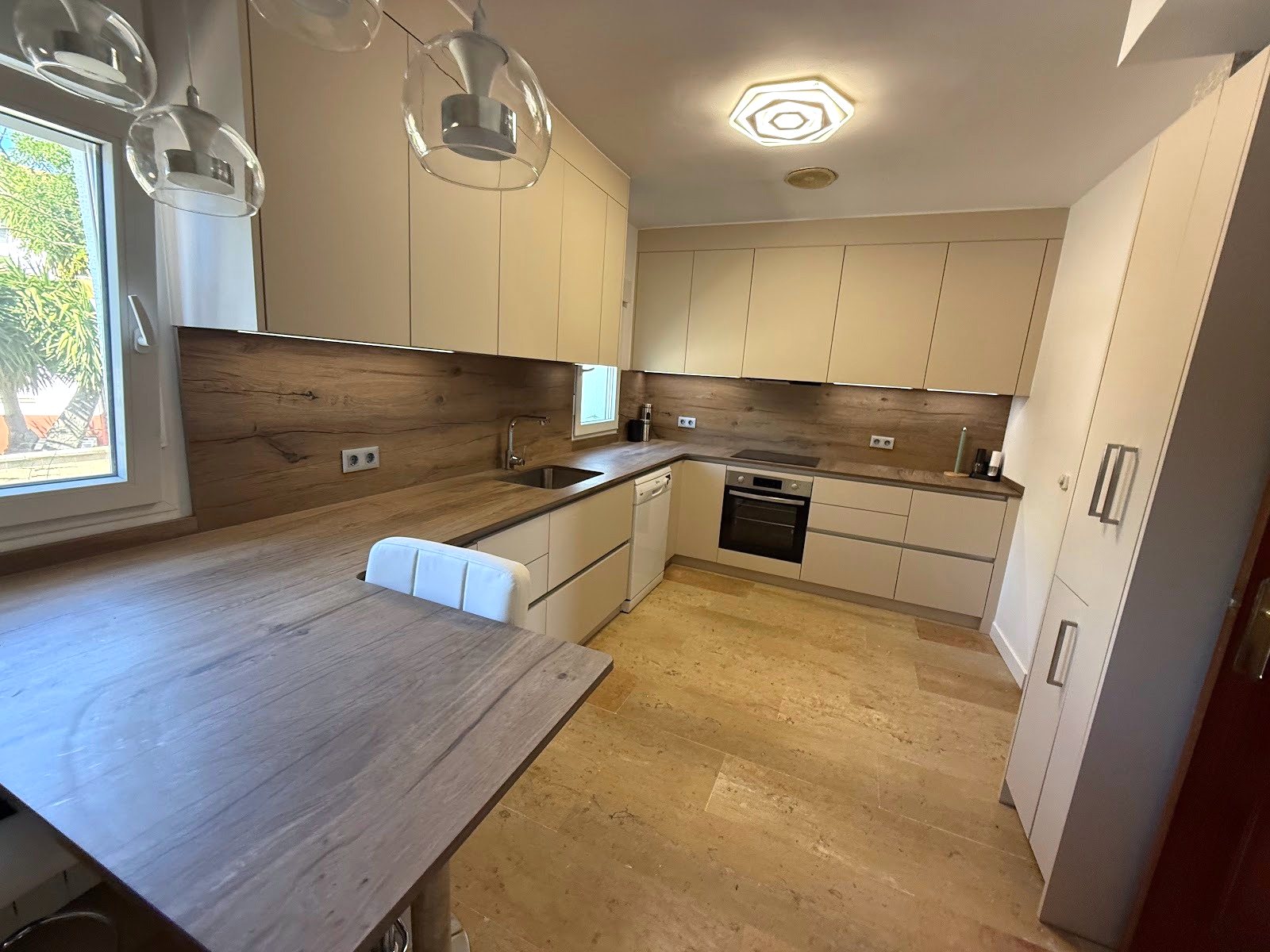 La cocina terminada vista desde la barra, con la encimera de madera corrida